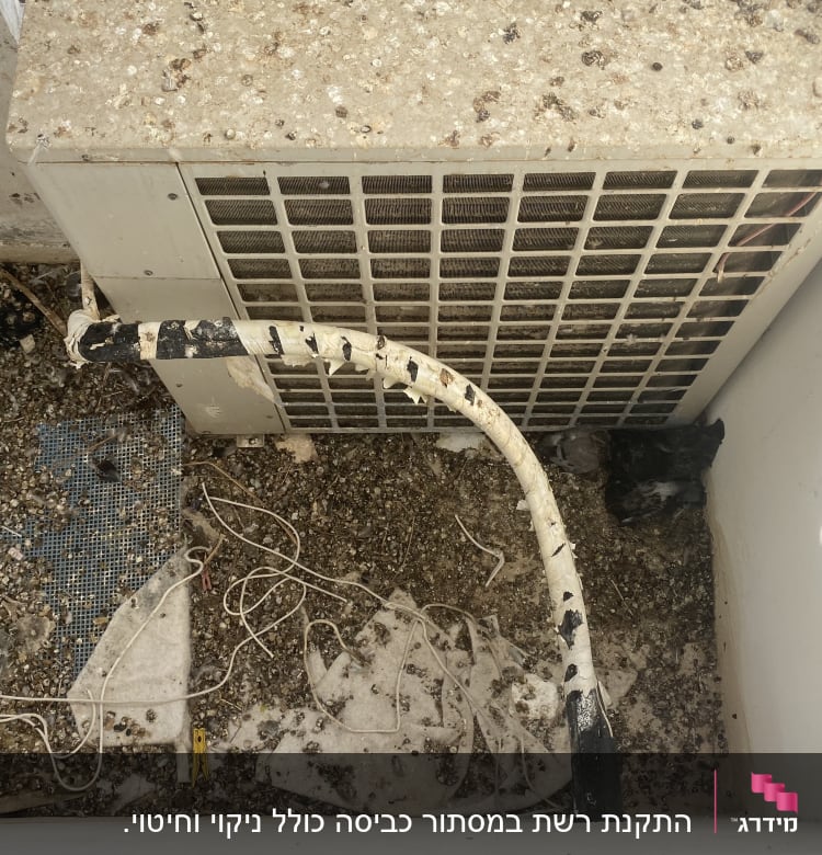 יחידת מזגן עם חוטים ופסולת על הקרקע